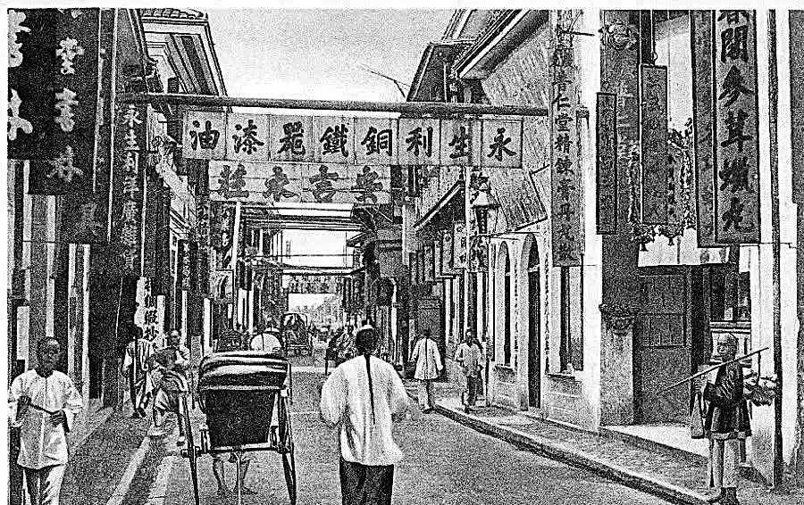 曹光彪接手鸿祥呢绒店后的上海街景旧影，店铺招牌与行人清晰可辨